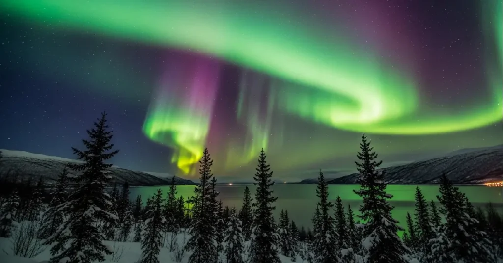 Northern Lights Aurora Borealis reflecting on fjord near Tromso Norway