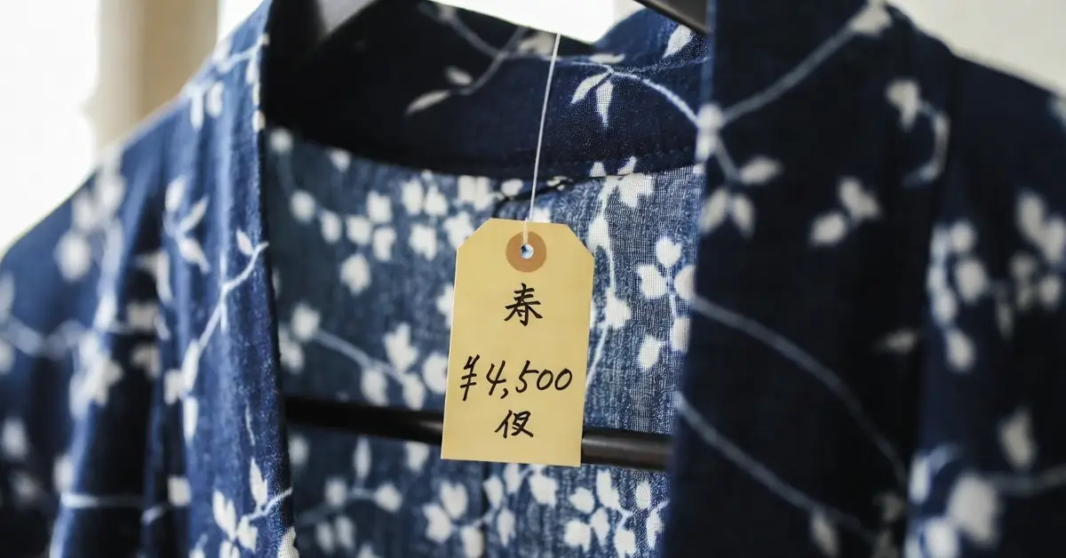 Close up of a handwritten yellow price tag on a silk kimono, 4500 yen, from a second hand kimono shop in Tokyo Japan


