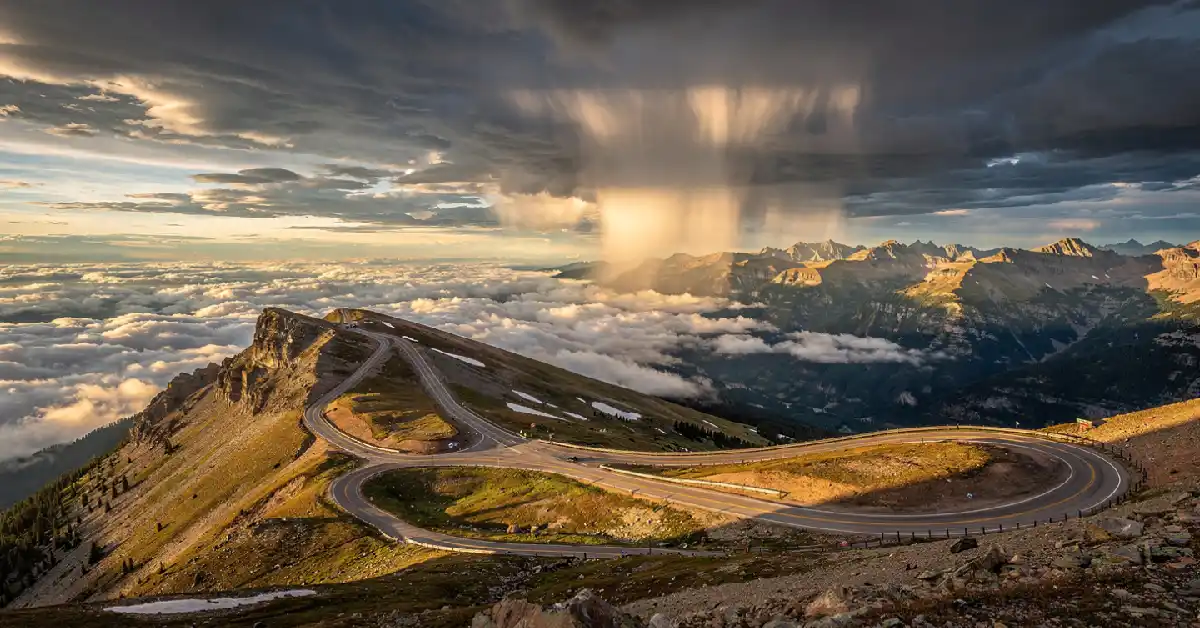Empty Trail Ridge Road winding through alpine tundra above the clouds in Rocky Mountain National Park Colorado
