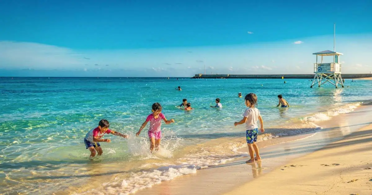 Emerald Beach Okinawa with kids playing in shallow water
