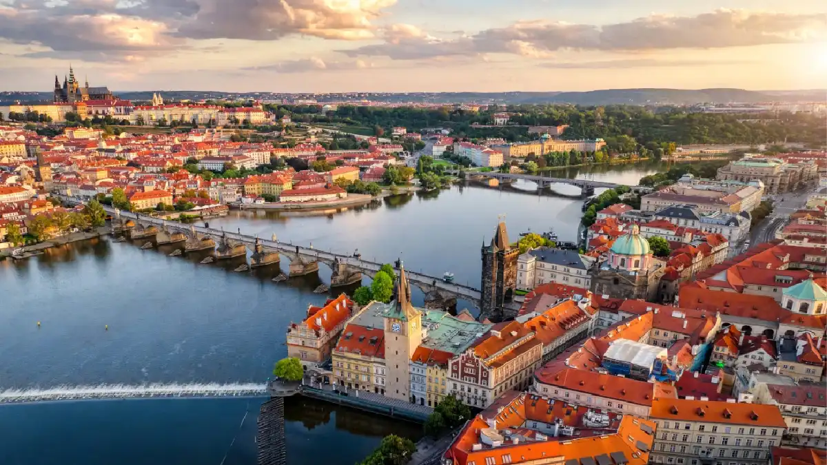 Prague Old Town rooftops and Charles Bridge at golden hour, Eastern Europe travel guide.